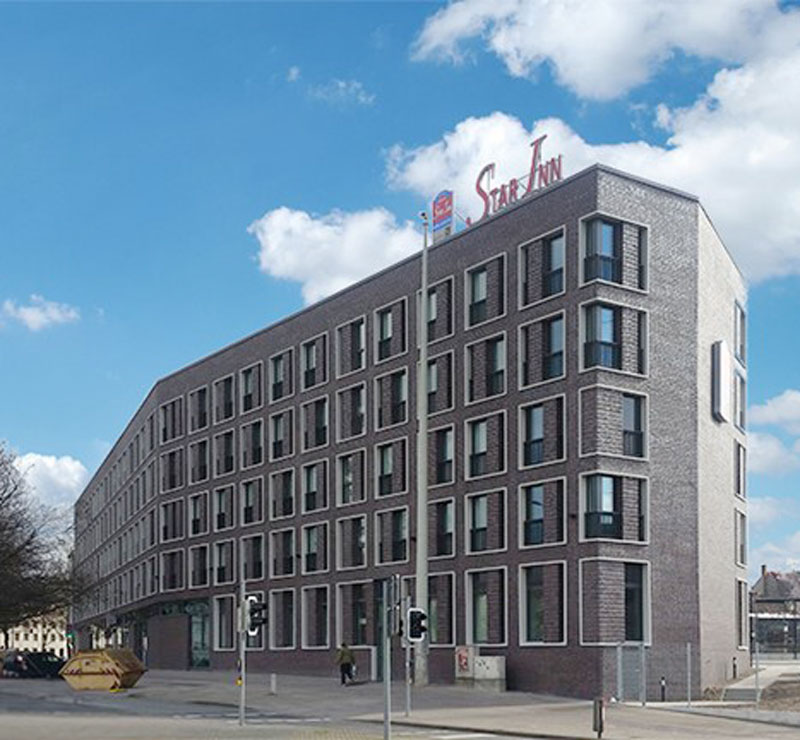 großes graues Gebäude mit Klinkerfassade, blauer Himmel
