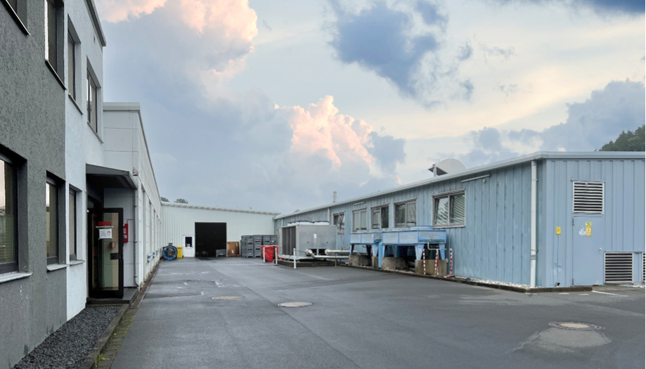 Industriegebiet, blaues einstöckiges Gebäude und asphaltierter Platz